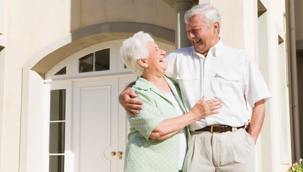 elderly couple look at each other infront of door