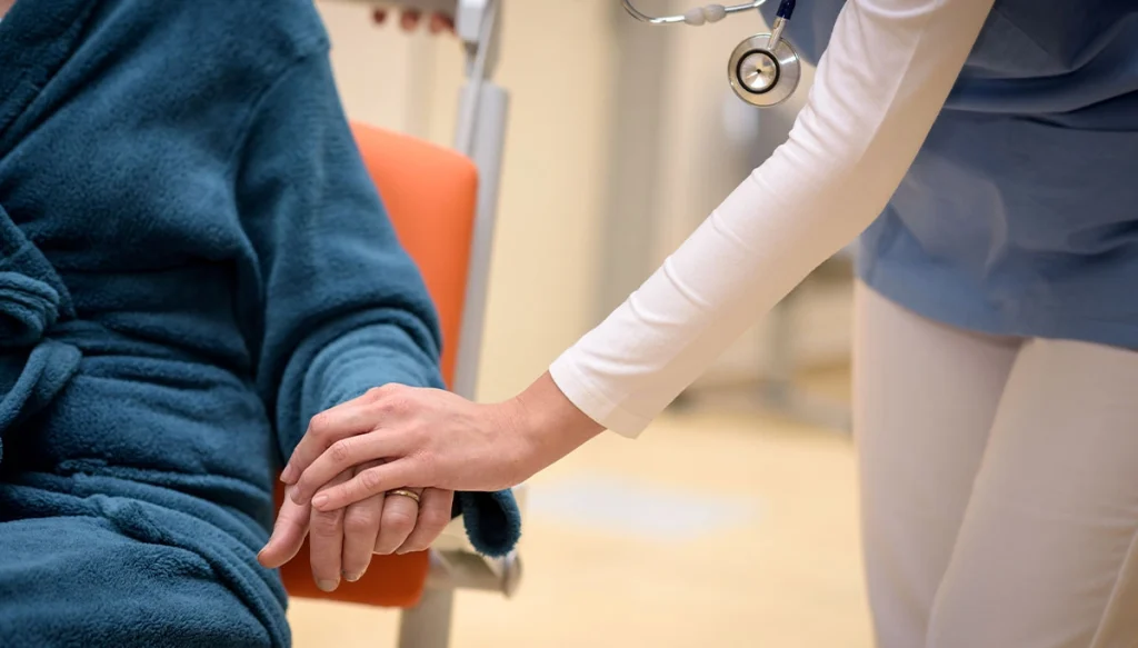 loved one holding the hand of an elderly person