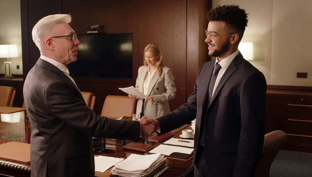 man shaking hands with an attonrey in a boardroom