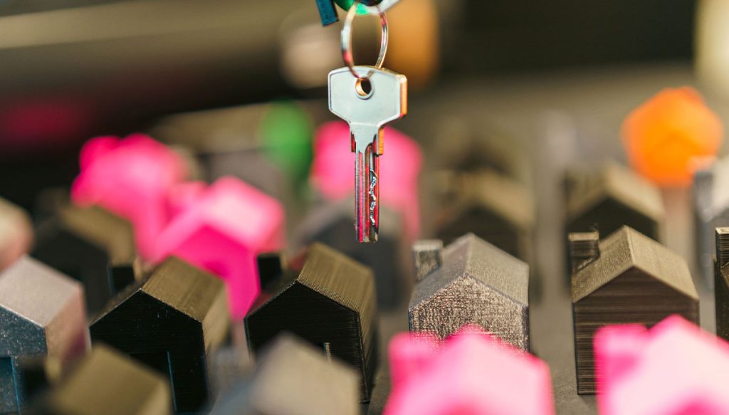 a key above colorful miniature houses