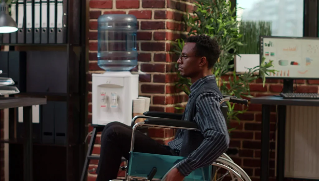young man sitting in a wheel chair in an office